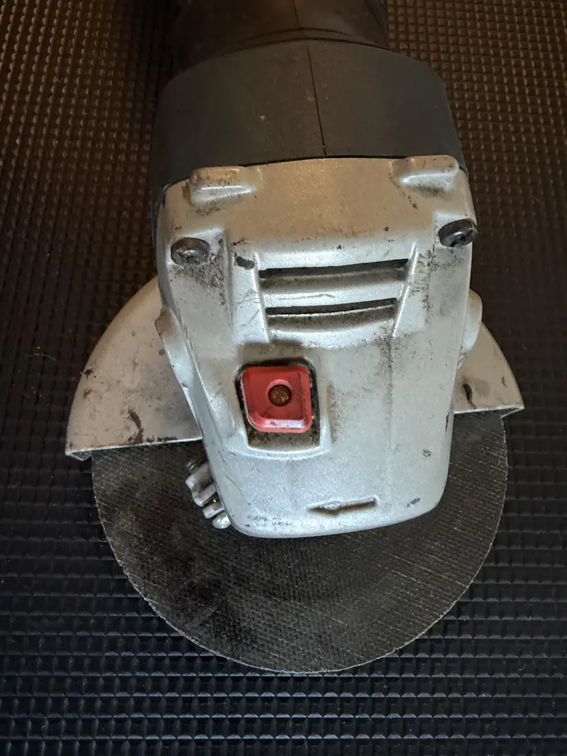 Getriebekopf des Bosch GWS 18-125 V-LI mit Spindelarretierung, Schutzhaube und Gebrauchsspuren