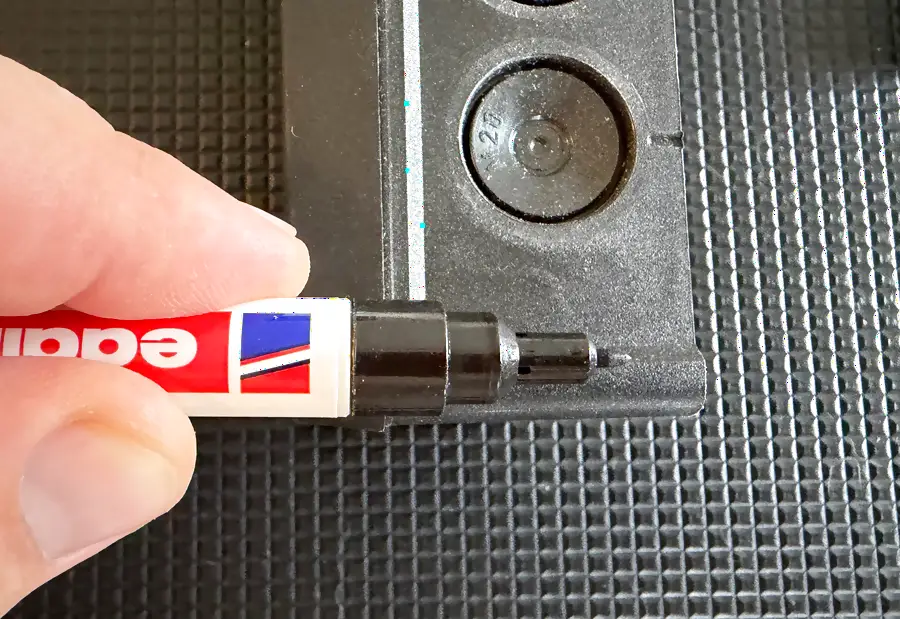 Ein Edding-Permanentmarker, dessen Spitze nicht bis zum Grund des tief liegenden Schraublochs reicht
