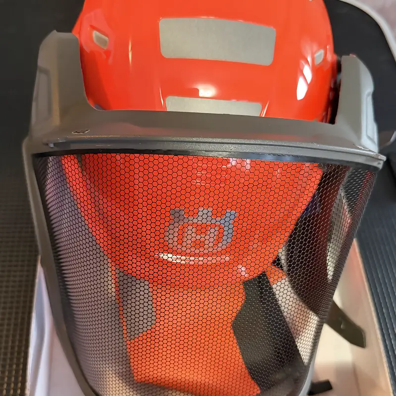 Husqvarna Technical Forsthelm mit heruntergeklapptem Netzvisier und Reflexstreifen auf der Schale