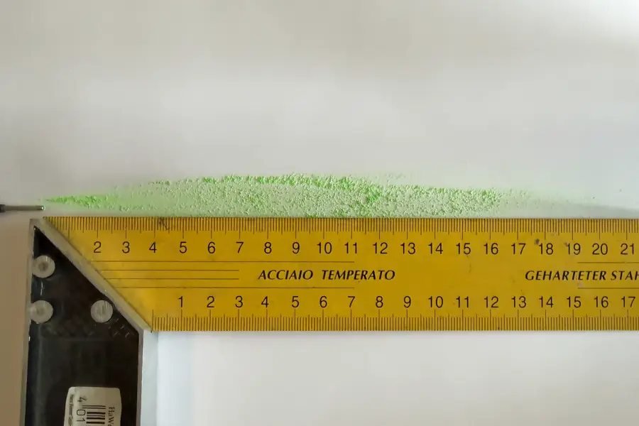 Grüne Kreidespur des Pica Powder neben einem Lineal auf weißem Papier, rund 20 Zentimeter lang