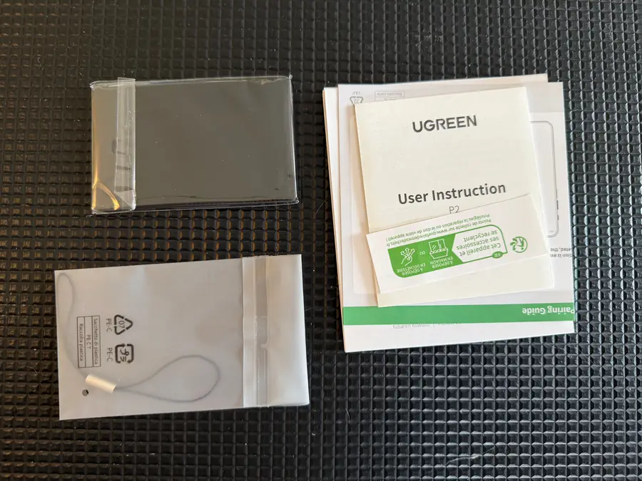 Lieferumfang des UGREEN Finder Slim 3: Karte in Folie, Trageschlaufe im Beutel, Anleitung und Pairing-Guide